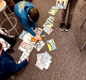 Students assembling a collaborative poster in a middle school classroom